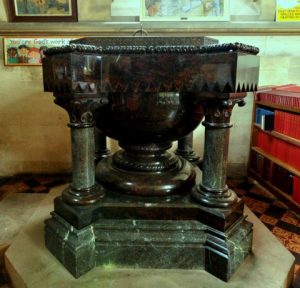 The wonderfully heavy font is Red Cornish serpentine on a granite plinth. Its lid is so heavy it needs two strong men to lift it when the font is needed for a baptism (Brian Belton)